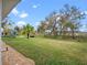 Spacious backyard with lush green lawn, mature trees, and gravel pathway at 4609 Inverness Dr, Leesburg, FL 34748