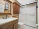 Traditional bathroom features a wood vanity, marble countertop, and a glass-enclosed shower at 4609 Inverness Dr, Leesburg, FL 34748