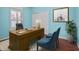 Home office features a wood desk, blue accent chairs, and light blue walls at 4609 Inverness Dr, Leesburg, FL 34748