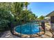 Private backyard pool with a safety fence, surrounded by lush landscaping, perfect for summer enjoyment at 4830 Tellson Pl, Orlando, FL 32812