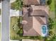 An aerial view of a home with a brown roof and a screened-in pool, surrounded by a lush green lawn at 4955 Ne 124Th Rd, Oxford, FL 34484