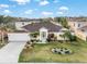 Aerial view of a well-maintained single-story home with lush landscaping and a charming front yard at 4955 Ne 124Th Rd, Oxford, FL 34484