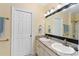 Bathroom featuring double vanities, granite countertops and a decorative mirror at 4955 Ne 124Th Rd, Oxford, FL 34484