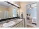 Bathroom with double sinks, granite countertop, and view of a bedroom at 4955 Ne 124Th Rd, Oxford, FL 34484