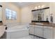 Bright bathroom featuring a large soaking tub, granite countertops, and a spacious vanity at 4955 Ne 124Th Rd, Oxford, FL 34484