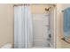 Bright bathroom featuring a tub and shower with striped curtain at 4955 Ne 124Th Rd, Oxford, FL 34484