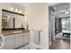 Bathroom featuring a granite vanity, decorative mirror and a view to outdoor living at 4955 Ne 124Th Rd, Oxford, FL 34484