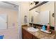 View of the bathroom vanity, mirror, and sink with a glimpse into an adjacent room at 4955 Ne 124Th Rd, Oxford, FL 34484