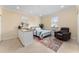 Cozy bedroom with tiled floors, a kitchenette, queen bed, leather chair, and natural lighting at 4955 Ne 124Th Rd, Oxford, FL 34484