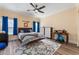 Spacious bedroom featuring a bed, desk, and large window with blue curtains at 4955 Ne 124Th Rd, Oxford, FL 34484