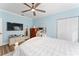 Bright bedroom with a ceiling fan, wood floors, white trim, and comfortable bed at 4955 Ne 124Th Rd, Oxford, FL 34484