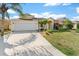 Inviting single-story home with a spacious driveway, well-kept lawn, and lush landscaping at 4955 Ne 124Th Rd, Oxford, FL 34484