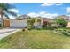 Charming single-story home with a landscaped front yard and palm trees at 4955 Ne 124Th Rd, Oxford, FL 34484