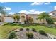 Well-maintained front yard with a single-story home, lush landscaping, and rock garden at 4955 Ne 124Th Rd, Oxford, FL 34484