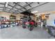 Well-organized garage with storage shelves, tools, and a red golf cart at 4955 Ne 124Th Rd, Oxford, FL 34484