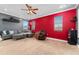 Media room featuring gray walls, a red accent wall, projector, and comfortable seating at 4955 Ne 124Th Rd, Oxford, FL 34484