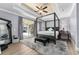 Spacious main bedroom featuring a four-poster bed, tray ceiling, and sliding glass doors to the patio at 4955 Ne 124Th Rd, Oxford, FL 34484