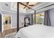 Main bedroom showing a four-poster bed, tray ceiling, sliding glass doors to the patio, and ensuite bathroom at 4955 Ne 124Th Rd, Oxford, FL 34484