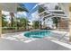 A beautiful pool with a waterfall feature is surrounded by a screened-in lanai and lush landscaping at 4955 Ne 124Th Rd, Oxford, FL 34484