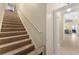 View of the carpeted staircase leading up to the second floor, with a hallway and door in the background at 4955 Ne 124Th Rd, Oxford, FL 34484