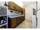 Practical laundry room with overhead cabinets, utility sink, ample counter space, and white appliances at 5200 Ne 20 St, Ocala, FL 34470