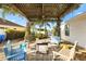 Inviting backyard seating arrangement under a pergola, offering a cozy space for gathering and enjoying the outdoors at 544 Audrey Ln, The Villages, FL 32162