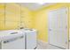 Bright laundry room with washer, dryer, utility sink, and ample shelving for storage at 544 Audrey Ln, The Villages, FL 32162