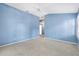 Large, empty room with neutral carpeting and light blue walls at 544 Audrey Ln, The Villages, FL 32162