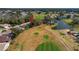 Aerial view of the property, showcasing its location on the golf course and proximity to a pond with mature landscaping at 544 Grand Vista Trl, Leesburg, FL 34748