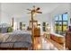 Main bedroom featuring hardwood floors, a four-poster bed, and large windows at 544 Grand Vista Trl, Leesburg, FL 34748