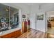 Hallway featuring hardwood floors, a decorative chest, and access to the lanai at 544 Grand Vista Trl, Leesburg, FL 34748