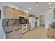 Bright kitchen with tile floors, light wood cabinets, granite countertops, and modern appliances at 544 Grand Vista Trl, Leesburg, FL 34748