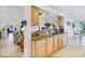 Bright kitchen featuring granite counters, light wood cabinets, stainless steel sink, and tile flooring at 544 Grand Vista Trl, Leesburg, FL 34748