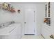 This laundry room features white walls and tile flooring, as well as modern washer and dryer at 544 Grand Vista Trl, Leesburg, FL 34748