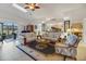 Comfortable living room featuring plush sofas, a ceiling fan, and an open kitchen view at 544 Grand Vista Trl, Leesburg, FL 34748