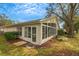 Exterior view of sunroom with lots of windows, surrounding foliage and small stone walkway at 544 Grand Vista Trl, Leesburg, FL 34748