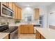 Bright kitchen with stainless steel appliances, tiled backsplash, and wood cabinets at 559 Juniper Springs Dr, Groveland, FL 34736