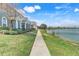 Scenic view of a sidewalk beside a row of homes, showcasing a serene lake view and lush green lawns at 559 Juniper Springs Dr, Groveland, FL 34736