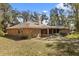 Brick home's backyard featuring mature trees, with a screened-in porch, offering a serene outdoor living space at 580 Mercers Fernery Rd., Deland, FL 32720