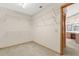 Bright walk-in closet with built-in white wire shelving, neutral walls, and doorway to an ensuite bathroom at 580 Mercers Fernery Rd., Deland, FL 32720