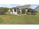 Green backyard featuring a screened lanai, perfect for outdoor entertaining and relaxation at 602 Catalina Ct, Lady Lake, FL 32159