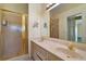 Bathroom featuring double sinks, light wood cabinets, and a gold framed glass enclosed shower at 602 Catalina Ct, Lady Lake, FL 32159