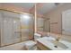 Bathroom with white tile, gold accents and glass doors and a large mirror at 602 Catalina Ct, Lady Lake, FL 32159