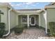 Welcoming front entrance featuring a covered porch, pavers, and well-maintained landscaping at 602 Catalina Ct, Lady Lake, FL 32159