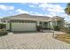 Inviting single-story home featuring a two-car garage, paved driveway, and lush landscaping at 602 Catalina Ct, Lady Lake, FL 32159