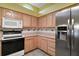 Kitchen featuring a stainless steel refrigerator, built-in microwave, and electric range oven at 602 Catalina Ct, Lady Lake, FL 32159