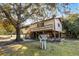 Exterior view of home with charming, elevated porch, and large shade tree at 6490 Se 180Th Avenue Rd, Ocklawaha, FL 32179