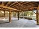 View of concrete pad beneath stilt house with wooden beams and fenced in yard at 6490 Se 180Th Avenue Rd, Ocklawaha, FL 32179