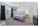 Cozy bedroom with neutral carpeting, ceiling fan, and natural light from the window at 701 Brigadoon Cir, Leesburg, FL 34788