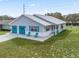 Charming single-story home featuring a metal roof, two-car garage, and well-manicured lawn at 701 Brigadoon Cir, Leesburg, FL 34788